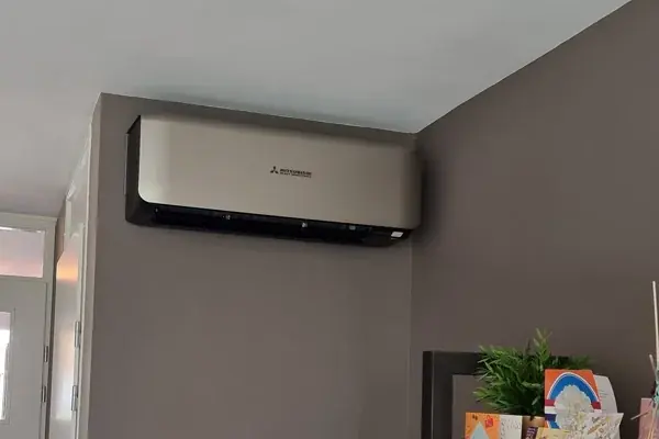 Witte airco boven de bank in een lichte woonkamer