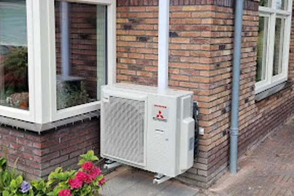 Buitenunit netjes tegen een bakstenen gevel geplaatst